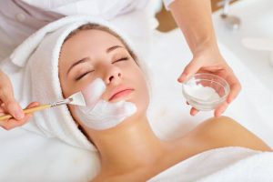 woman relaxing while someone puts a mask on her face